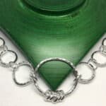 silver necklace on a green background