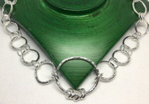 silver necklace on a green background 