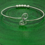 silver bracelet on green background