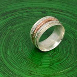 silver and copper ring on green background
