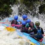 people in blue and yellow raft on rapids